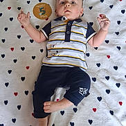 Malo a rejoint le concours — aidez-le/la à gagner de superbes lots ! baby, infant, child, lying_down, striped_shirt, navy_pants, blanket, heart_pattern, sign, 5_months, cute, hand_gesture, curious, relaxed, indoors, portrait, young_child, clothing, foot, face