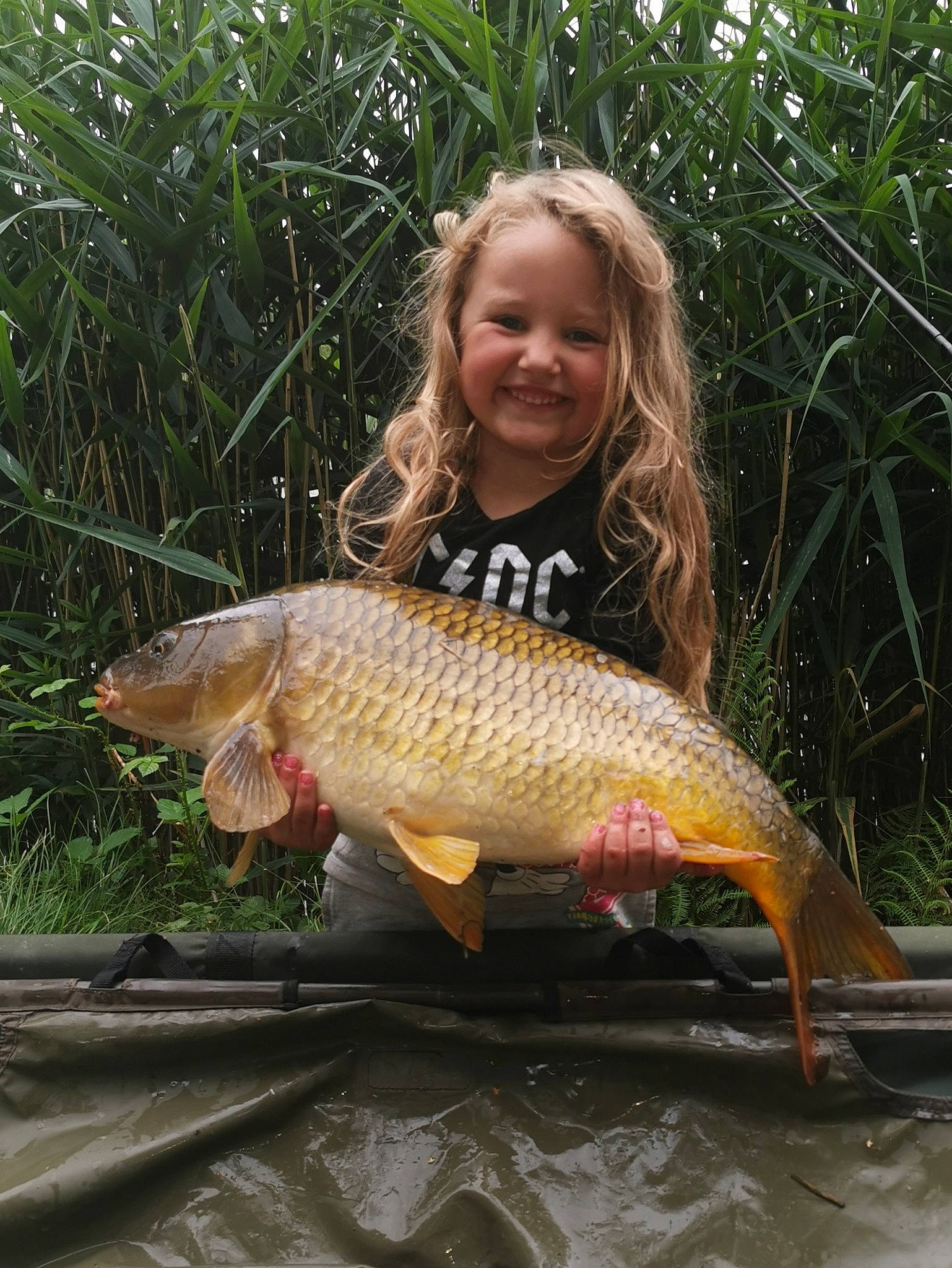 Elyana a rejoint le concours — aidez-le/la à gagner de superbes lots ! cyprinidae, feeder_fish, fish, fisherman, fishing, grass, joy, people_in_nature, person, plant, pond, ray_finned_fish, recreation, recreational_fishing, shorts, smile, t_shirt, tail, terrestrial_plant, vertebrate