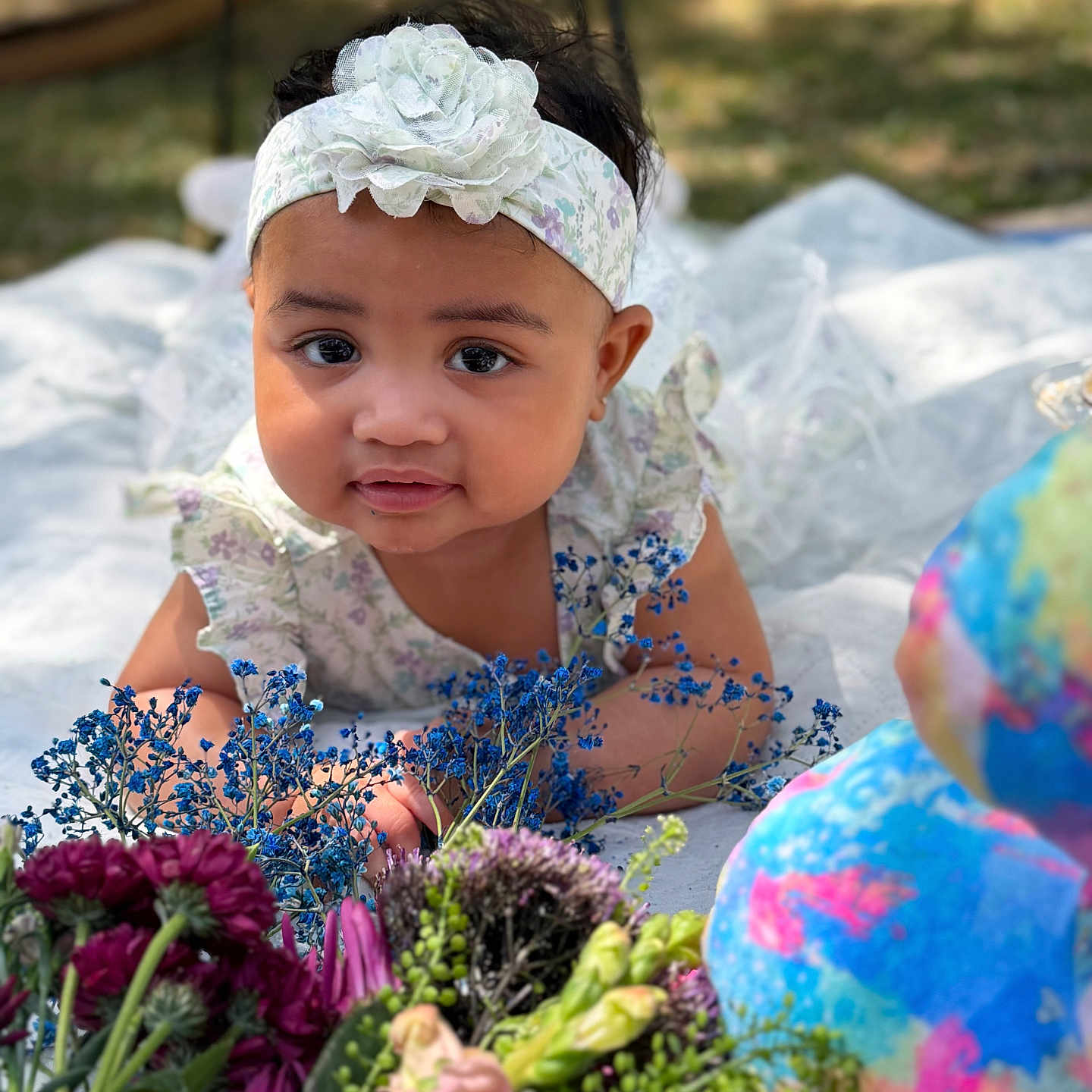 Alexis Sade is registered to the contest to win money with this photo: baby, child, flower, headband, outdoor, nature, portrait, cute, dress, blanket, colorful, greenery, infant, smiling, young, bright, garden, flora, closeup, happy