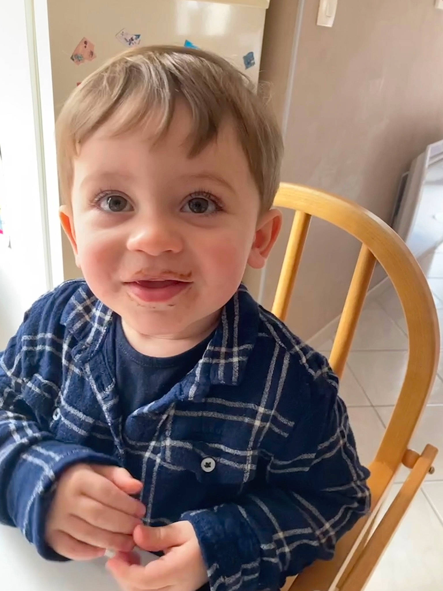 Sören participe au concours pour gagner de l'argent avec cette photo : chair, cheek, child, chin, dress_shirt, fun, gesture, iris, pattern, person, plaid, product, sitting, sleeve, smile, t_shirt, tartan, thumb, toddler, wrist