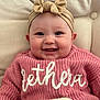 baby, smiling, headband, bow, pink_sweater, knitwear, cute, infant, portrait, face, happy, child, clothing, cozy, indoor, person, closeup, cuteness, warm, soft_background