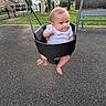 baby, child, swing, playground, park, outdoor, infant, fence, trees, bench, grass, houses, daylight, black_swing, curious, expression, footwear_free, casual_clothing, summer, recreation