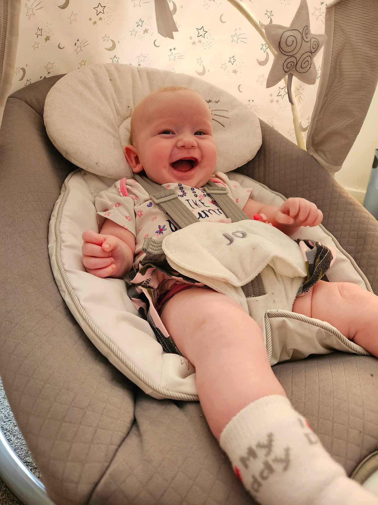 Miah joined the competition — help win amazing prizes! baby, smiling, infant, baby_seat, cushion, harness, sock, clothing, indoor, happy, cute, child, person, fabric, toy, pattern, head_support, star, moon, baby_toys