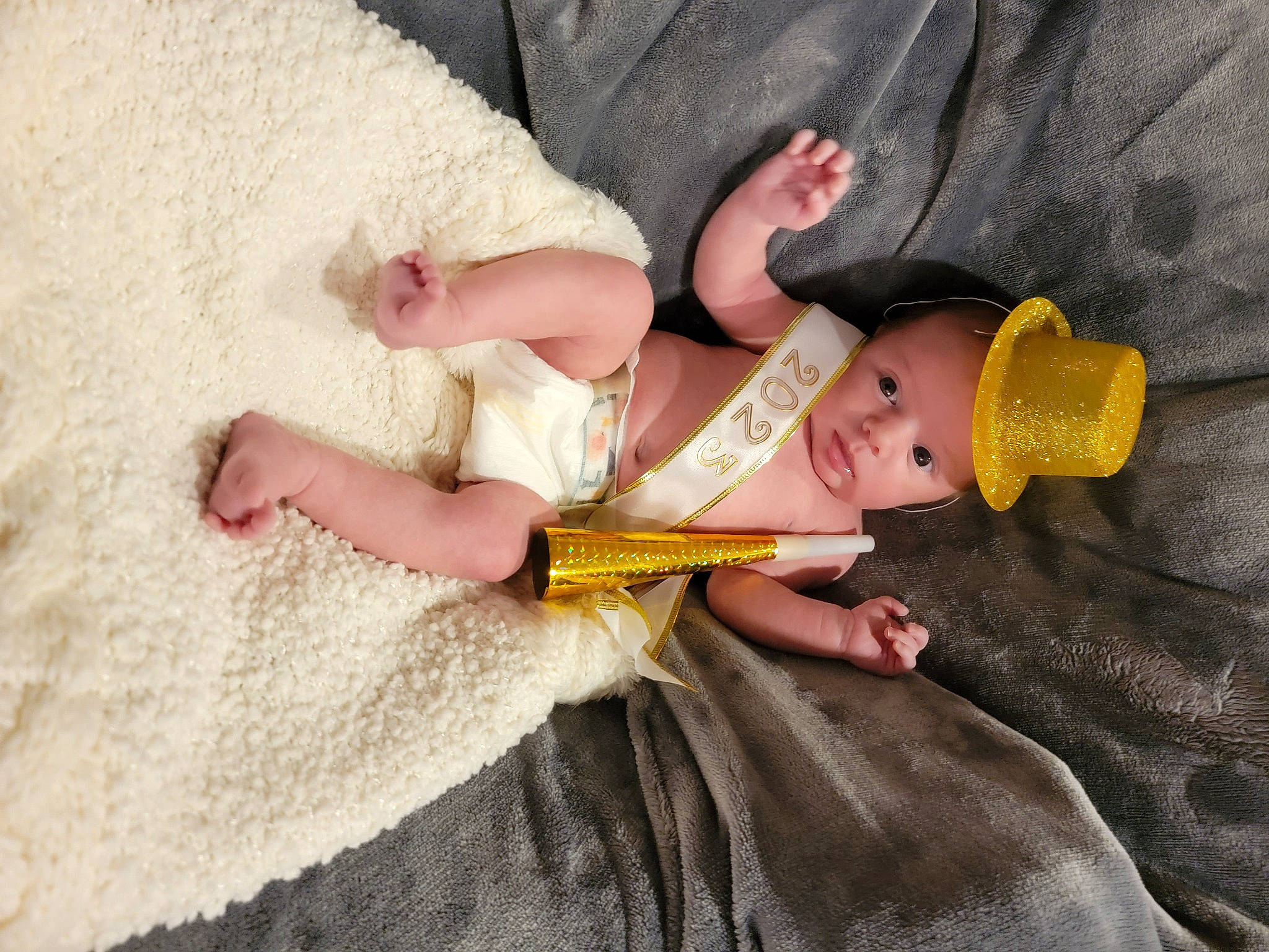 Marceline is registered to the contest to win money with this photo: baby, baby_products, baby_toddler_clothing, child, comfort, eye, face, fawn, finger, foot, fun, hat, headgear, headwear, human_body, leg, linens, nail, person, sitting