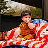 baby, child, cap, overalls, american_flag, blanket, cowboy_boots, cake, birthday_candle, outdoor, truck_bed, celebration, half_birthday, cute, sitting, footwear, person, hat, plaid, nature