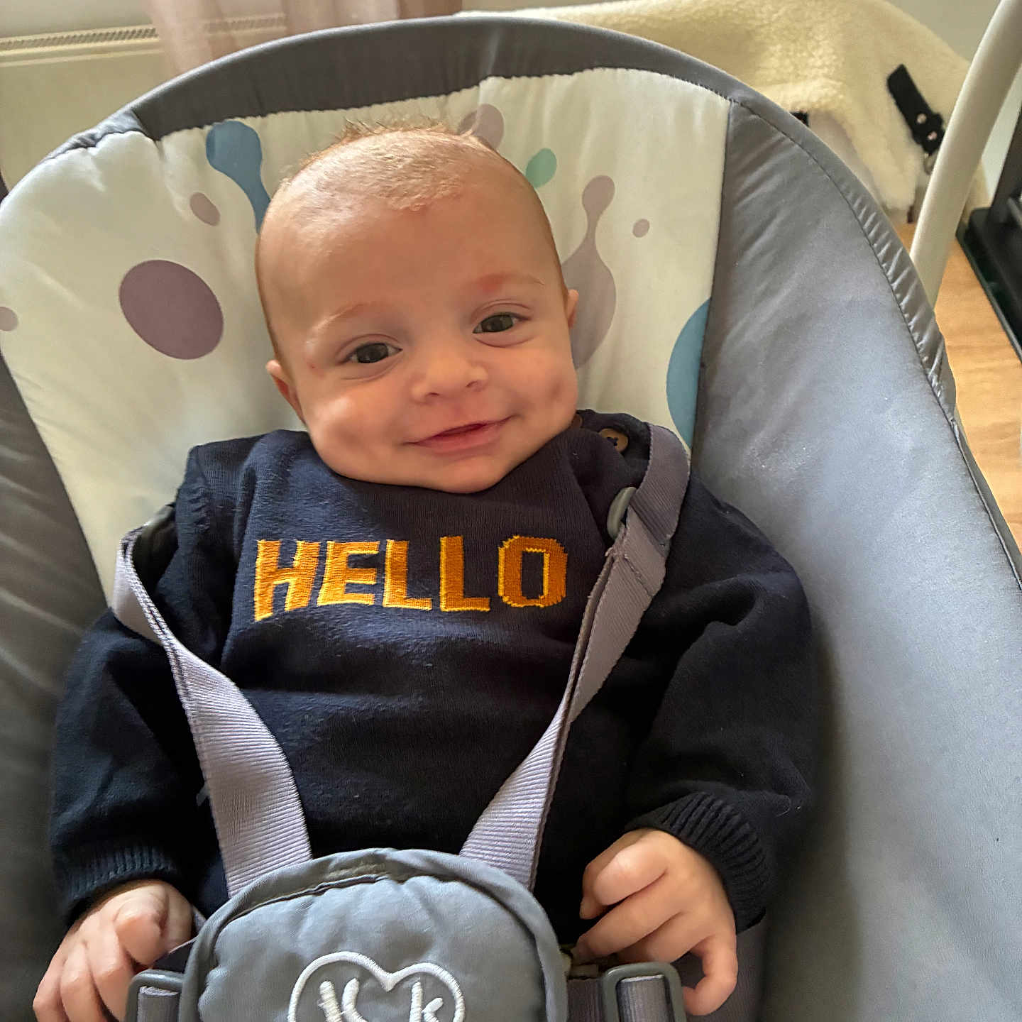 Elyno a rejoint le concours — aidez-le/la à gagner de superbes lots ! baby, smiling, infant, baby_seat, sweater, text_on_clothing, straps, indoor, curtains, cozy, child, comfort, happy, person, portrait, clothing, face, hand, seat, striped_pants