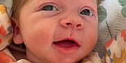 Ivy joined the competition — help win amazing prizes! baby, infant, face, smile, clothing, onesie, pattern, floral, blanket, closeup, newborn, cute, child, person, sleepwear, happy, soft, skin, young, lying