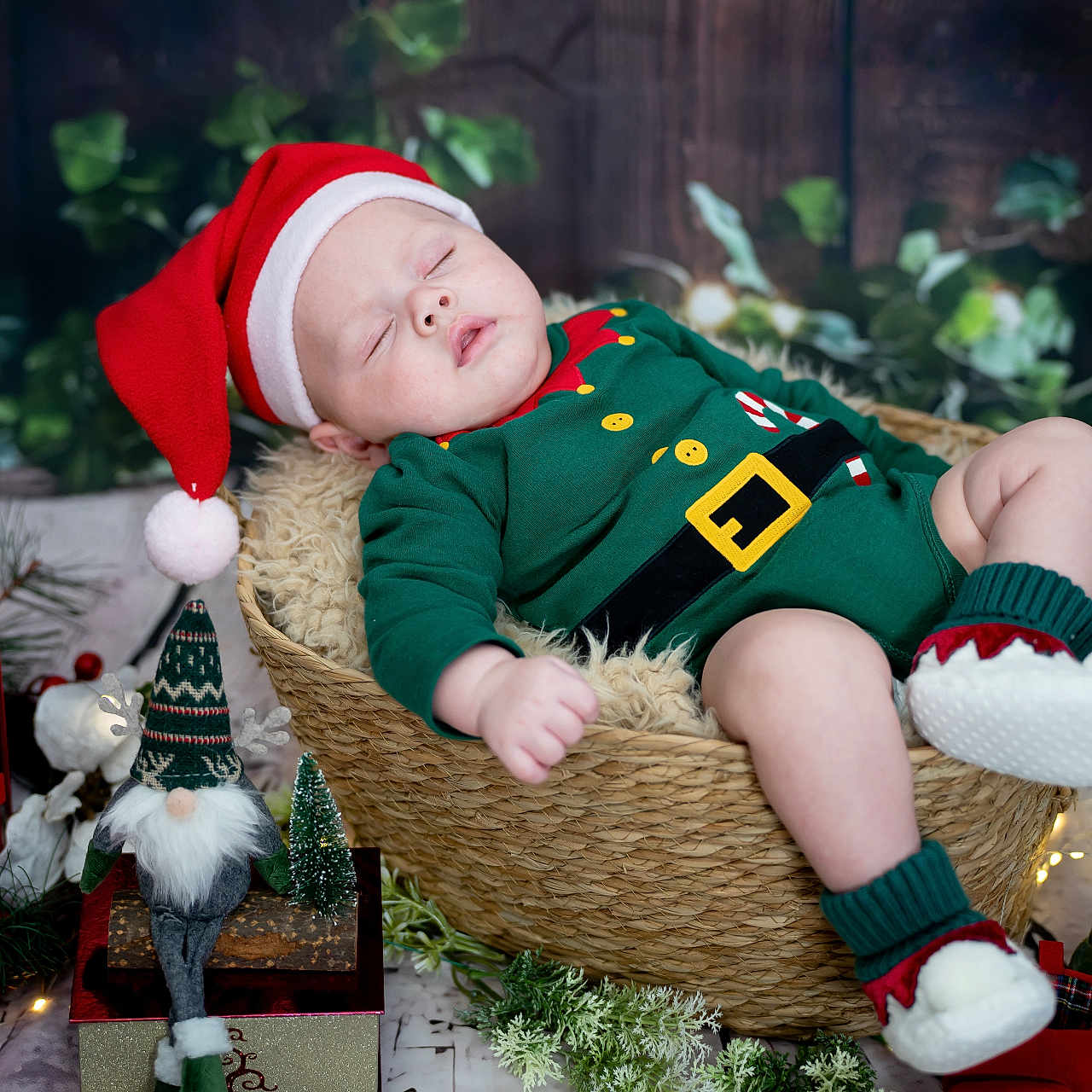 Elijah Finn joined the competition — help win amazing prizes! baby, basket, christmas, cozy, cute, decorations, elf_outfit, fairy_lights, festive, gnome, greenery, holiday, indoors, lantern, plush, red_shoes, santa_hat, seasonal, sleeping, wood_floor