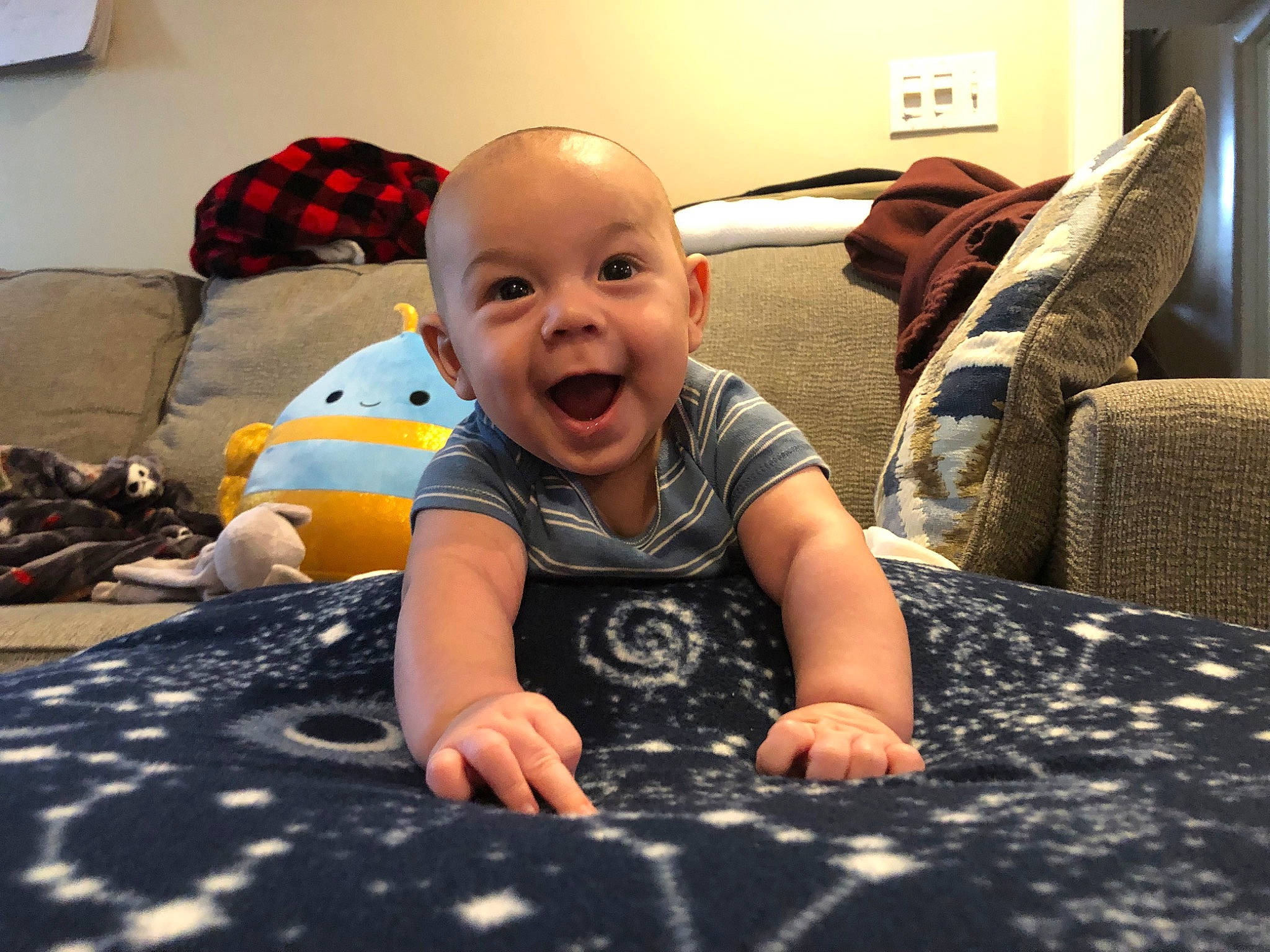 Angel is registered to the contest to win money with this photo: baby, baby_toddler_clothing, child, comfort, couch, crawling, floor, flooring, fun, happy, laugh, living_room, mouth, pattern, person, play, room, sitting, smile, toddler