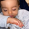 child, toddler, sleeping, closed_eyes, arm, hand, long_eyelashes, face, sweater, bracelet, beads, indoors, cozy, cute, peaceful, portrait, skin, blue_heart, digital_emoji, close_up