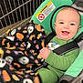 baby, shopping_cart, blanket, child, smiling, green_clothing, halloween, pumpkin, ghost, seatbelt, shopping, infant, happy, indoor, portrait, cute, toddler, face, person, retail
