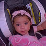 baby, child, car_seat, pink_bow, blanket, curly_hair, infant, seatbelt, closeup, cute, portrait, indoors, safety, headband, toddler, child_safety, soft_texture, young_child, person, looking