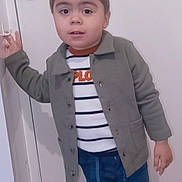 Roan participe au concours pour gagner de l'argent avec cette photo : barefoot, casual, child, clothing, curious, cute, door, expression, floor, hand_on_door, home, indoor, jacket, pants, person, portrait, standing, striped_shirt, toddler, young_child
