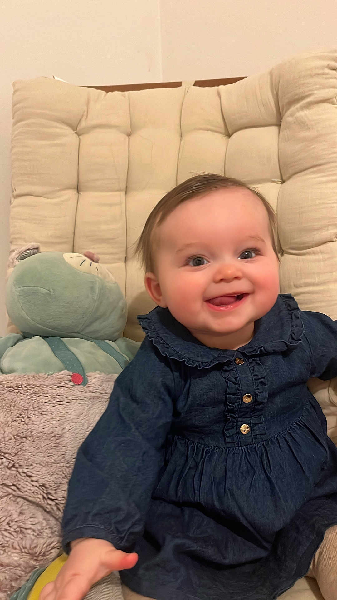 Alix participe au concours pour gagner de l'argent avec cette photo : baby, infant, smile, blue_dress, buttons, plush_toy, stuffed_animal, cushion, chair, hand, rosy_cheeks, bright_eyes, hair, indoor, portrait, seated, cozy_blanket, happy, cute, close_up
