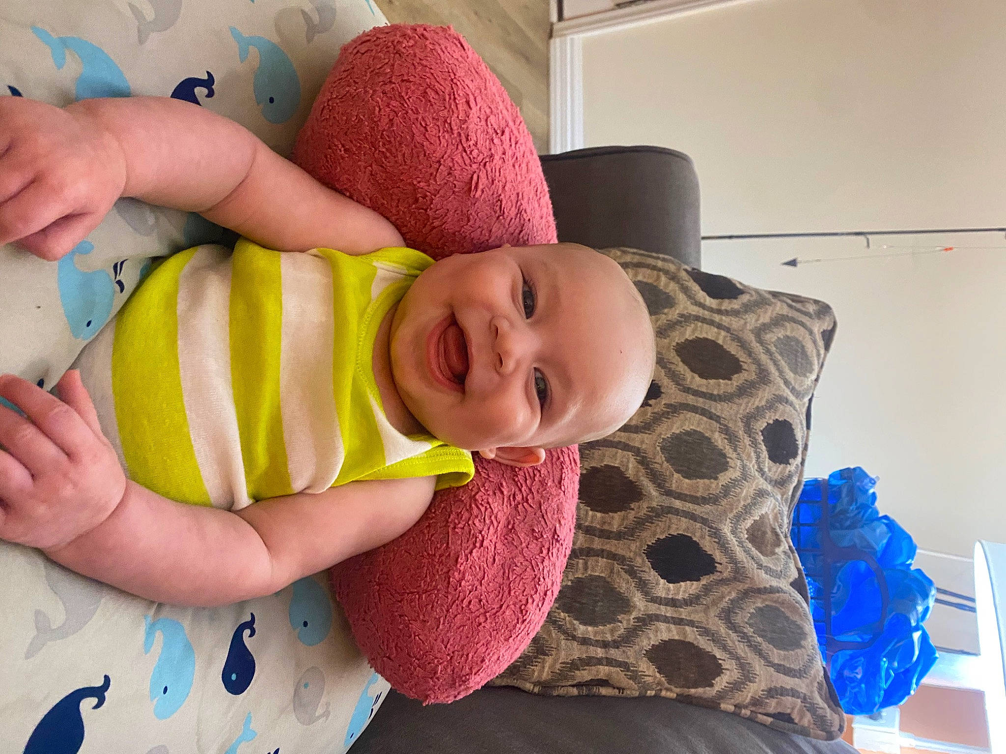 Braylen is registered to the contest to win money with this photo: arm, baby, baby_toddler_clothing, child, comfort, facial_expression, flooring, happy, headgear, human_body, joy, linens, pattern, person, pink, purple, skin, sleeve, smile, t_shirt
