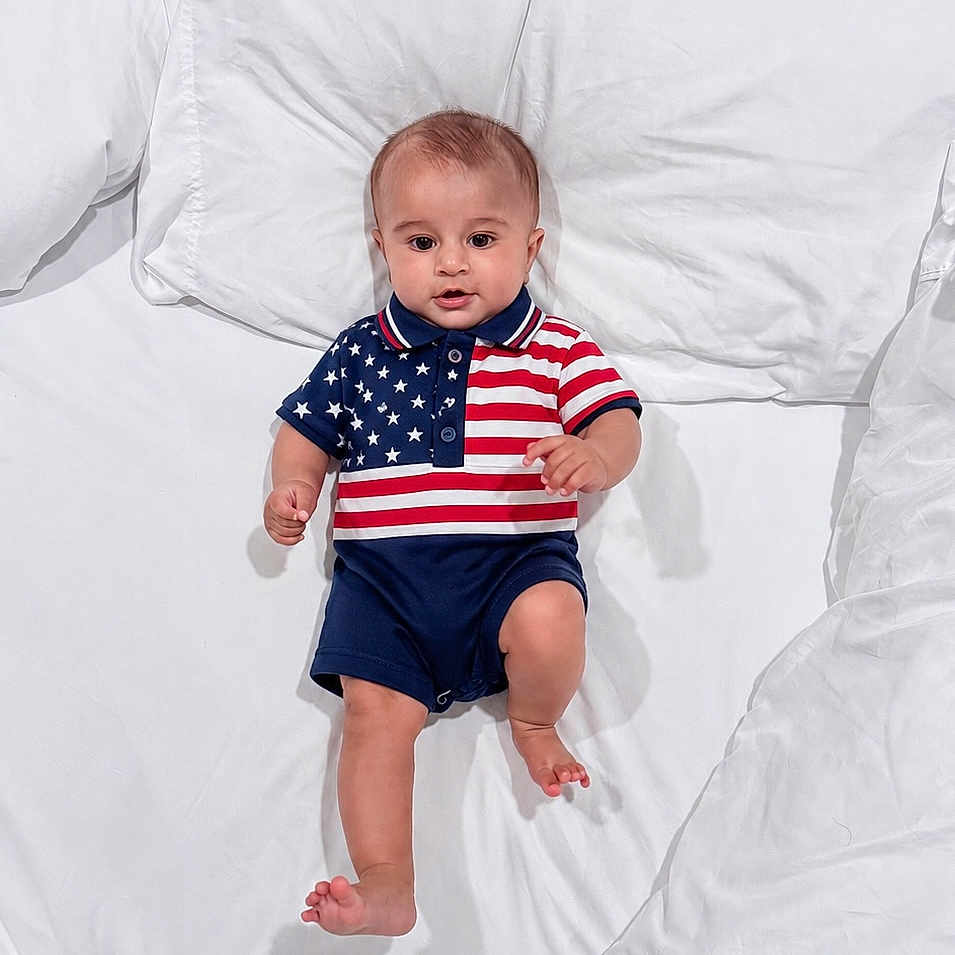 Mashfee joined the competition — help win amazing prizes! baby, bed, child, clothing, cute, feet, happy, head, indoors, infant, pajamas, patriotic, person, portrait, skin, sleepwear, smiling, stars, stripes, white_bed