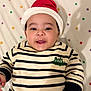 baby, child, smiling, face, hat, santa_hat, striped_clothing, sweater, lying_down, blanket, polka_dot, cute, festive, holiday, infant, portrait, happy, indoors, person, headwear