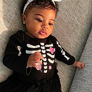 Jay'Lee is registered to the contest to win money with this photo: baby, infant, girl, headband, bow, earrings, black_clothing, skeleton_outfit, pink_hearts, lollipop, couch, gray_couch, tutu_skirt, cute, portrait, indoors, child, smiling, curious, closeup