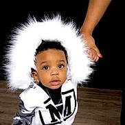 Trey joined the competition — help win amazing prizes! toddler, child, hood, jacket, white, black, fur, hand, adult, floor, indoor, portrait, curious, clothing, person, baby, fashion, cute, young, holding_hand