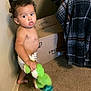 Orlando joined the competition — help win amazing prizes! toddler, child, diaper, toy, green_toy, curly_hair, carpet, cardboard_box, blanket, plaid_blanket, indoor, wall, standing, looking, expression, person, young_child, floor, home, casual