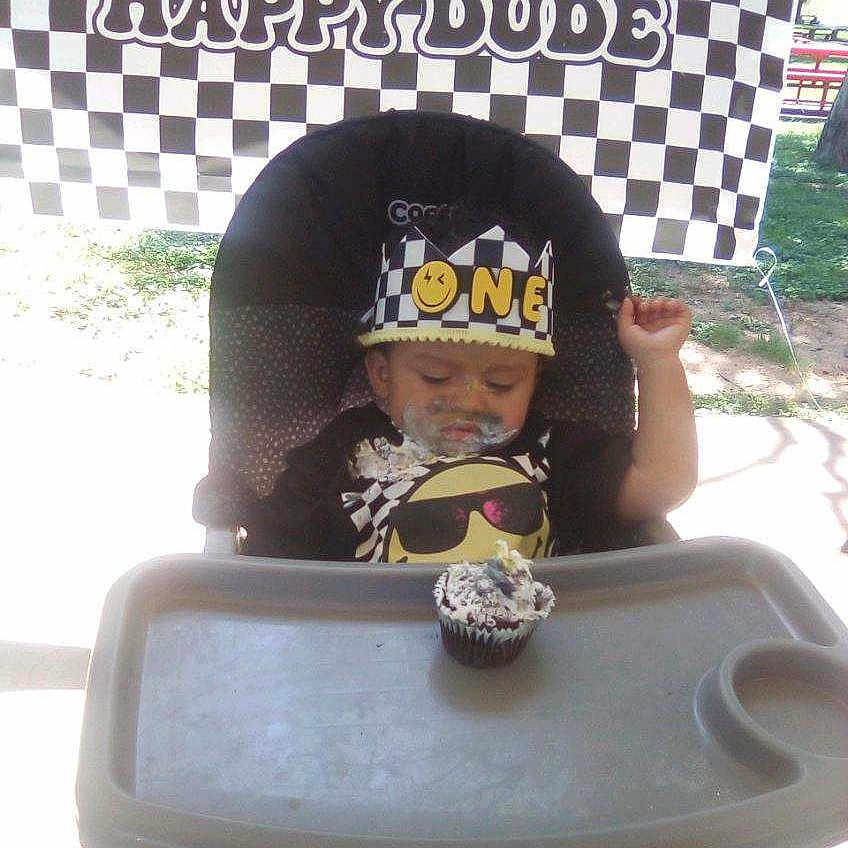 Orlando joined the competition — help win amazing prizes! baby, birthday, birthday_banner, black_clothing, celebration, cheerful, child, crown, cupcake, face_paint, food, frosting, hat, high_chair, messy, one_year_old, outdoor, party, smiling, sunny