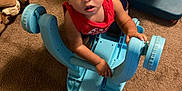 Orlando joined the competition — help win amazing prizes! toddler, child, toy, blue, plastic, carpet, indoor, curly_hair, red_shirt, looking_up, hand, floor, play, colorful, stuffed_animal, foot, furniture, home, expression, young