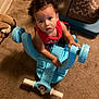 toddler, child, toy, blue, plastic, carpet, indoor, curly_hair, red_shirt, looking_up, hand, floor, play, colorful, stuffed_animal, foot, furniture, home, expression, young