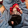 baby, bed, blanket, blue_blanket, clothing, comfort, cozy, feet, hands, headband, human, indoor, infant, mittens, newborn, person, red, resting, sleeping, soft_texture