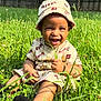 toddler, child, smiling, grass, outdoor, hat, casual_clothing, sunlight, nature, greenery, happy, sitting, portrait, baby, cute, accessory, playful, daytime, field, person