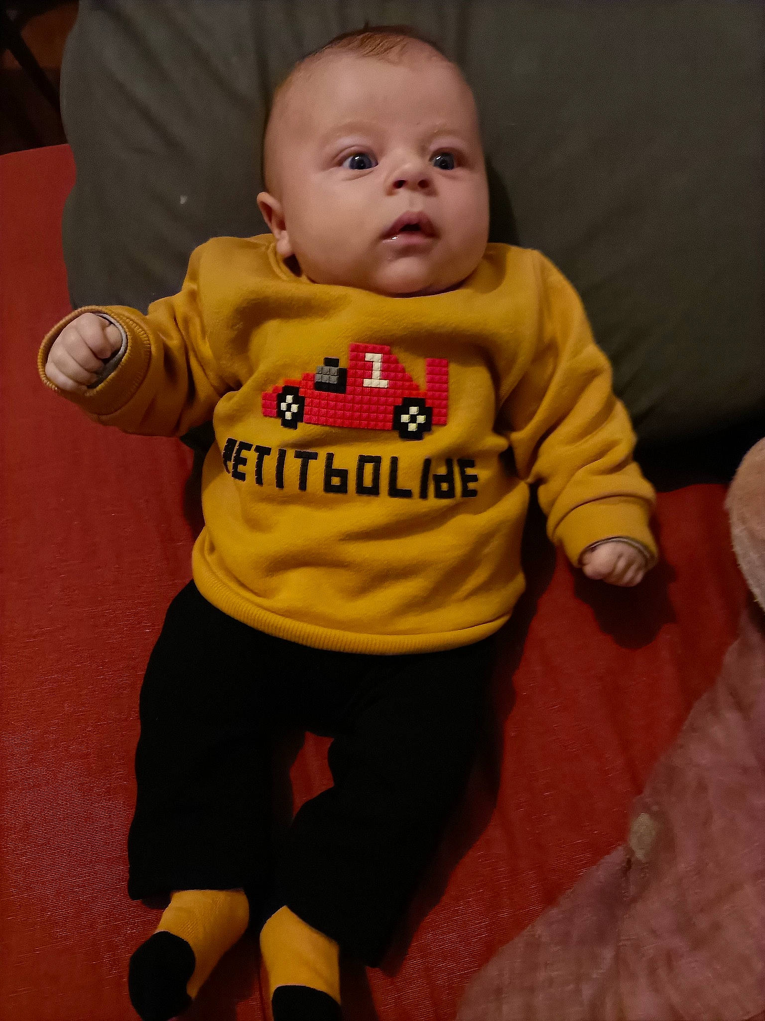 Cameron participe au concours pour gagner de l'argent avec cette photo : baby, baby_products, baby_toddler_clothing, cheek, child, chin, comfort, eye, flooring, fun, happy, head, long_sleeved_t_shirt, person, sitting, sleeve, sock, sportswear, t_shirt, thumb