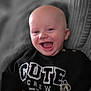 Archie joined the competition — help win amazing prizes! baby, infant, smiling, laughing, bald_head, portrait, closeup, sweatshirt, text_on_clothing, panda, couch, indoor, cozy, seat, happy, eyes, mouth, cheeks, pants, selective_color