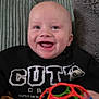 Archie is registered to the contest to win money with this photo: baby, infant, smiling, bald_head, toy_ball, colorful_toy, couch, cushion, floral_wallpaper, drooling, eyes, mouth, teeth, sweatshirt, pants, plush_pillow, portrait, happy, indoor, sitting