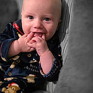Archie joined the competition — help win amazing prizes! baby, infant, toddler, hands_in_mouth, pajamas, teddy_bear, couch, sofa, close_up, portrait, bald_head, cheeks, smile, indoor, cozy, fabric_texture, holiday_pajamas, curious_expression, sitting, finger_chewing
