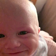 Archie is registered to the contest to win money with this photo: baby, smiling, close_up, face, hand, bib, striped_clothing, infant, cute, indoors, child, portrait, happy, young, skin, person, head, expression, newborn, soft_lighting