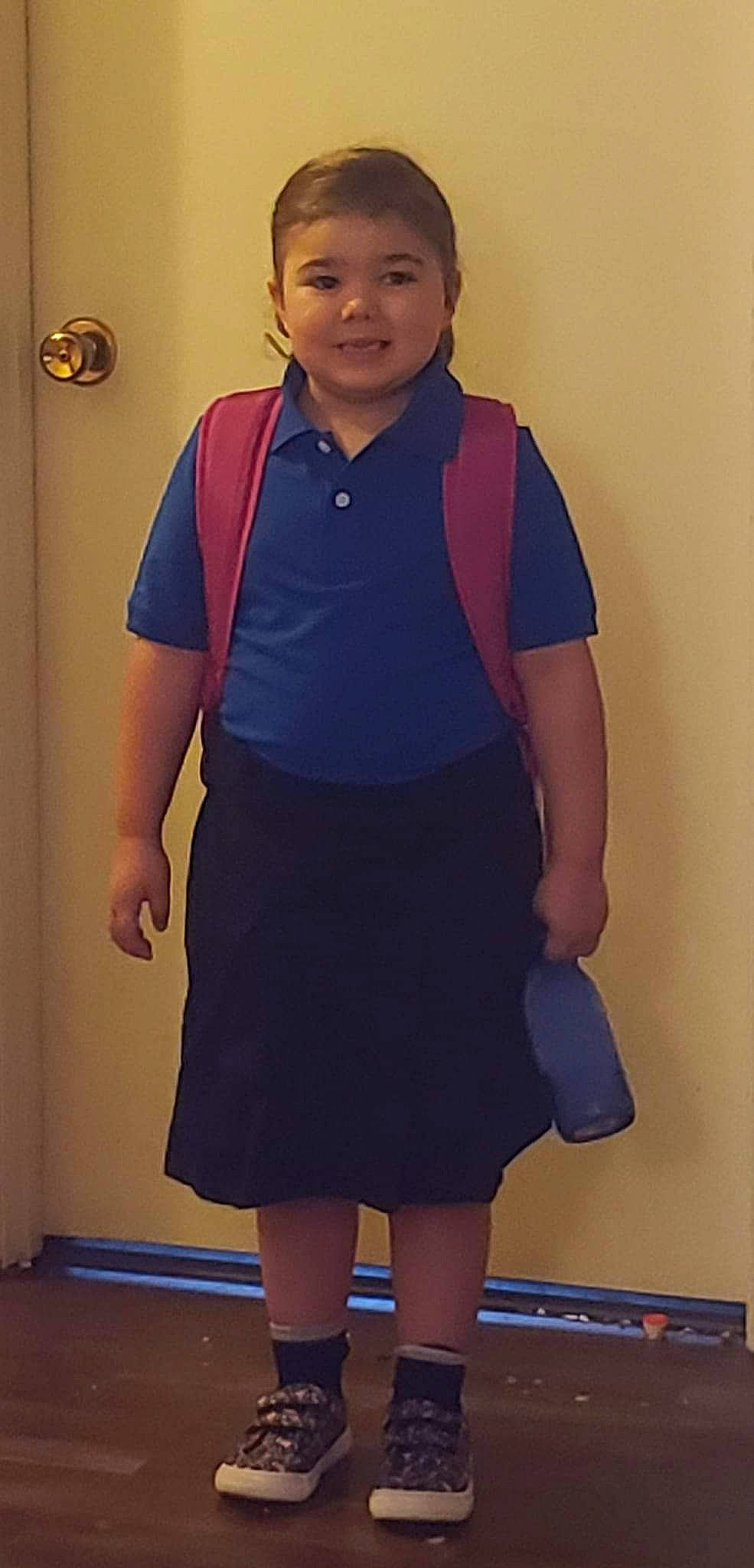 Zoe is registered to the contest to win money with this photo: blue, clothing, collar, door, electric_blue, event, fashion_design, formal_wear, joint, joy, knee, neck, person, purple, school_uniform, shoulder, sleeve, smile, thigh, trunk