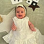 baby, infant, smiling, white_dress, headband, lying_down, carpet, star_pattern, play_cards, soft_toys, happy, cute, child, indoors, portrait, young_child, clothing, baby_girl, floor, decor