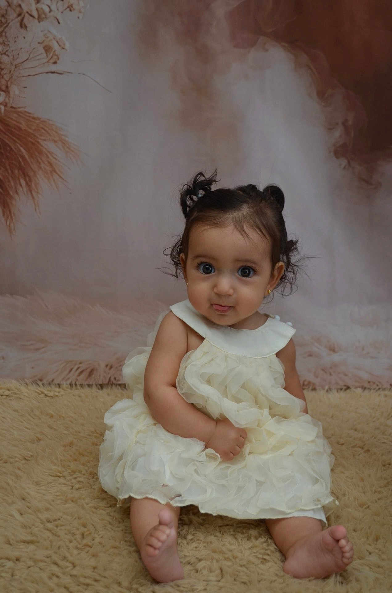 Laya participe au concours pour gagner de l'argent avec cette photo : baby, child, girl, dress, frilly, curly_hair, sitting, barefoot, carpet, portrait, cute, indoor, soft_lighting, expression, curious, small_ears, earrings, background, decor, young