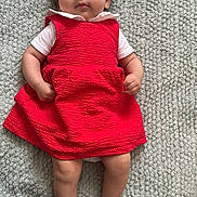 Laya a rejoint le concours — aidez-le/la à gagner de superbes lots ! baby, blanket, calm_expression, child, clothing, cute, face, feet, hands, indoors, infant, looking_at_camera, lying_down, person, portrait, red_dress, skin, soft_texture, white_shirt, young_child