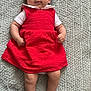 baby, blanket, calm_expression, child, clothing, cute, face, feet, hands, indoors, infant, looking_at_camera, lying_down, person, portrait, red_dress, skin, soft_texture, white_shirt, young_child