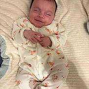 Luna participe au concours pour gagner de l'argent avec cette photo : baby, infant, smile, onesie, floral_pattern, blanket, soft_texture, lying_down, happy, cute, child, newborn, sleepwear, hands, face, cozy, indoors, portrait, young_child, comfort