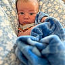 baby, infant, blanket, blue_blanket, patterned_blanket, cozy, cute, face, expression, portrait, newborn, soft_texture, wrapped, child, indoor, clothing, hands, head, skin, eyes