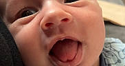 Hunter is registered to the contest to win money with this photo: baby, closeup, face, tongue_out, onesie, blue_clothing, infant, cute, playful, child, expression, portrait, smiling, indoors, person, head, skin, young_child, happy, baby_garment
