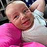 Hunter is registered to the contest to win money with this photo: arm, baby, blanket, child, closeup, couch, cute, face, happy, head, indoor, infant, person, pink_fabric, playful, resting, smiling, star_pattern, tongue_out, white_shirt