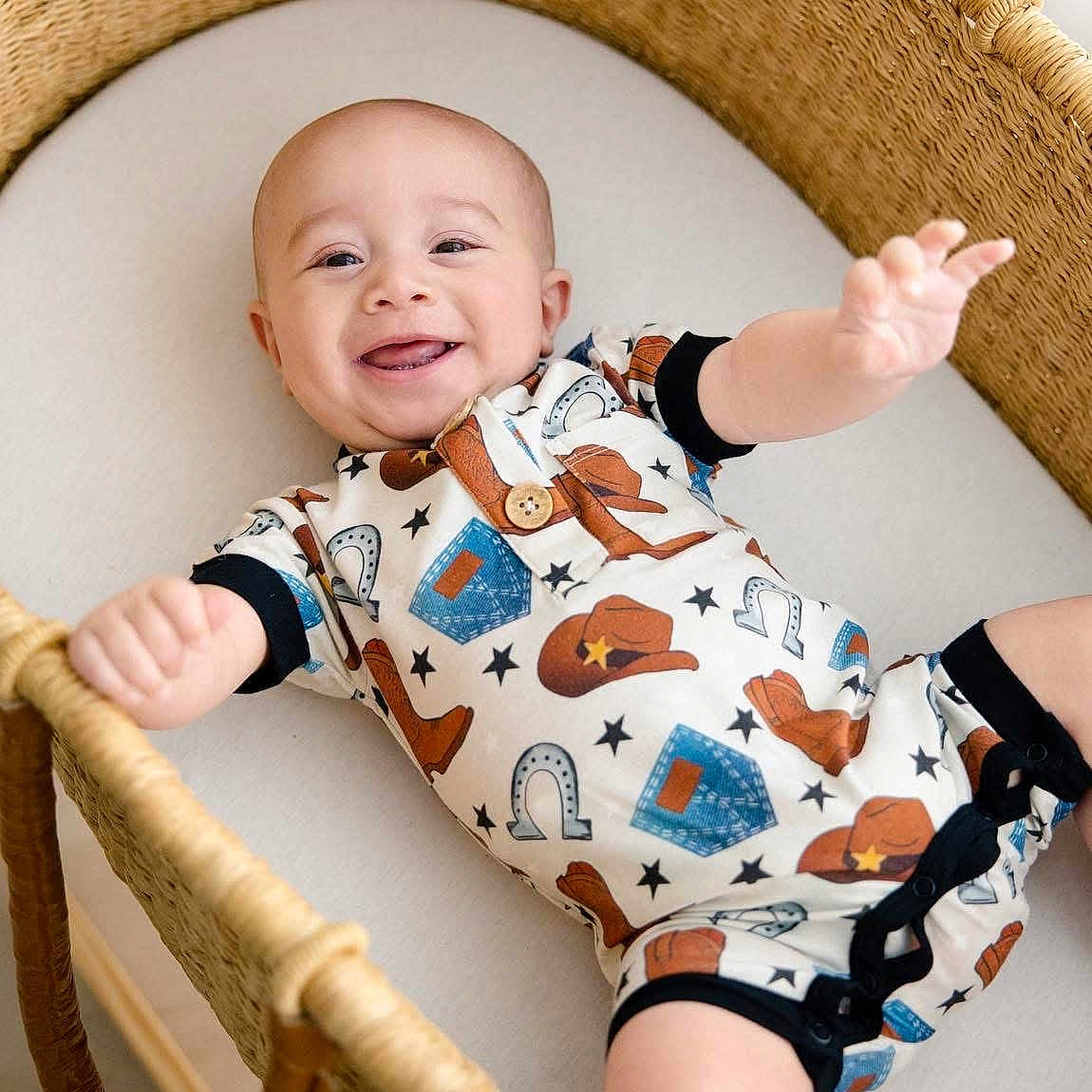 Bailor joined the competition — help win amazing prizes! baby, basket, bassinet, child, clothing, cowboy_outfit, cute, cute_expression, face, happy, indoor, infant, newborn, onesie, playful, portrait, reaching_out, skin, smiling, woven_furniture