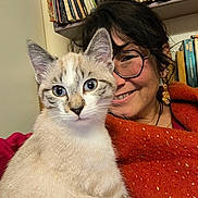 Willow participe au concours pour gagner de l'argent avec cette photo : bookshelf, cat, closeup, cozy, cute, earrings, ears, eyewear, face, feline, fur, glasses, home, indoor, orange_shawl, pet, portrait, sitting, smile, woman