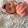 Elena is registered to the contest to win money with this photo: baby, infant, pink_headband, bow, close_up, reaching_hand, white_blanket, textured_blanket, soft_focus, portrait, cute, child, young_child, apparel, fabric, indoor, expression, skin, person, headwear
