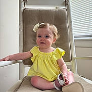 Wren joined the competition — help win amazing prizes! baby, child, girl, yellow_dress, bow, sandal, rocking_chair, cushion, indoor, window, natural_light, curly_hair, cute, smiling, person, furniture, seat, white, skin, happy