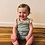 Wren joined the competition — help win amazing prizes! baby, child, smiling, happy, sitting, floor, wooden_floor, hair_clip, flower, cute, indoor, portrait, infant, person, skin, head, legs, hands, clothing, wall