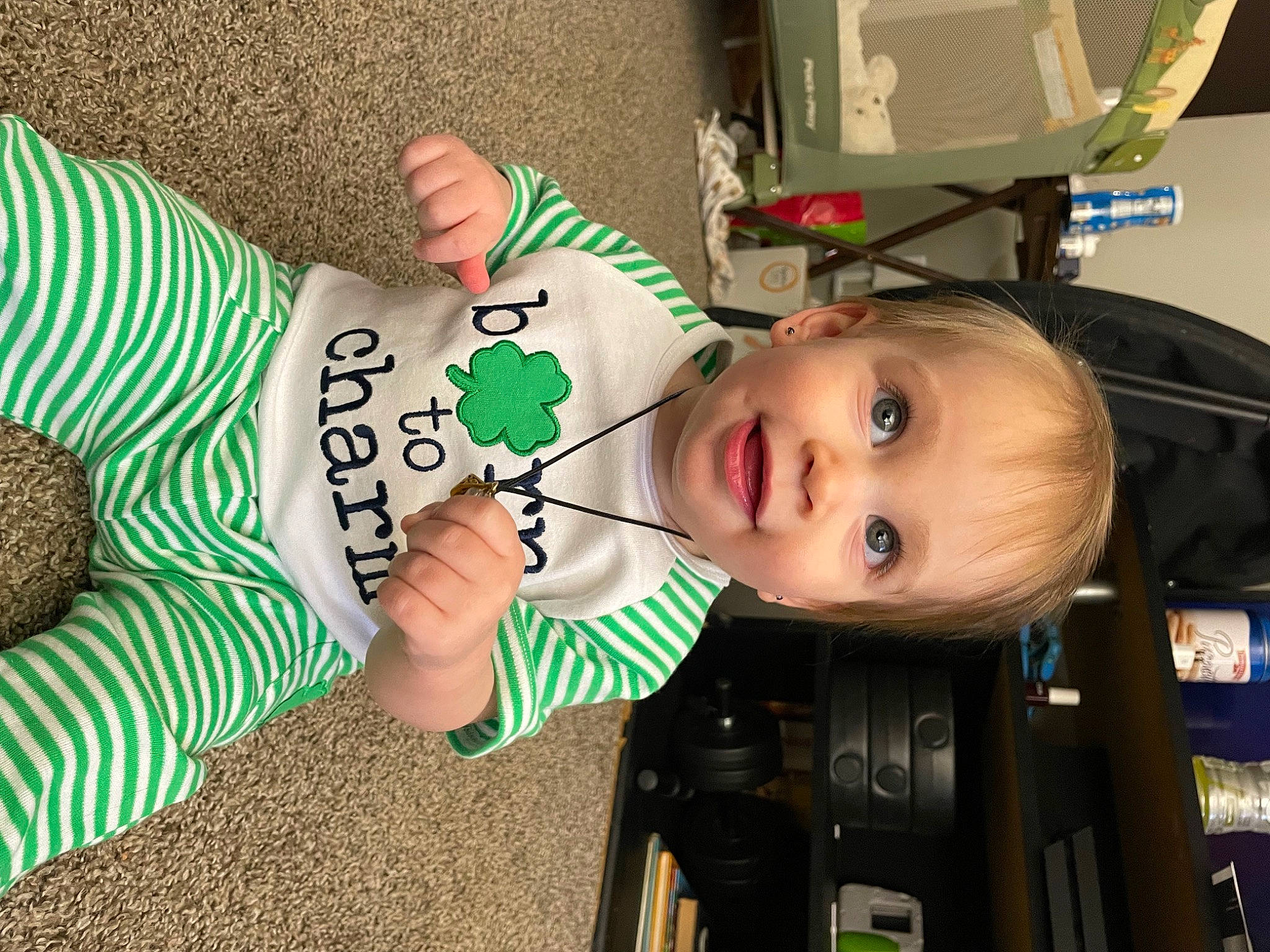 Haylie is registered to the contest to win money with this photo: baby, baby_products, child, flooring, fun, grass, happy, holiday, human_leg, pattern, person, sitting, smile, sock, toddler, toy, tree