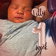Lilly is registered to the contest to win money with this photo: newborn, baby, sleeping, infant, portrait, face, eyes_closed, swaddled, blanket, gray_clothing, heart_balloon, pink_balloon, celebration, one_week_old, text_overlay, indoors, close_up, peaceful, family, photography